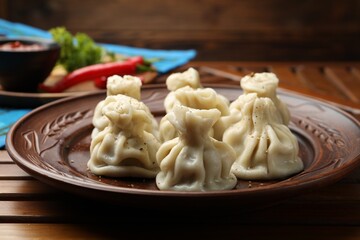 Delicious khinkali served on wooden table, closeup