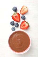 Baby food. Tasty puree in bowl and different ingredients on white wooden table, flat lay