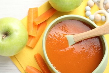 Baby food. Tasty puree in bowl, different ingredients and teether on table, flat lay