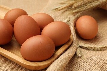 Fresh eggs and spikes on burlap cloth, closeup