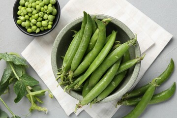 Fresh ripe green peas on grey table, flat lay