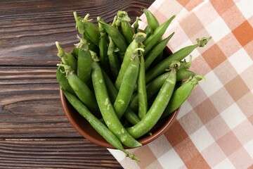 Fresh ripe green peas on wooden table, top view