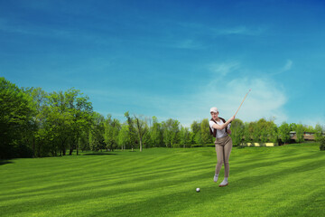 Woman with club playing golf on green course
