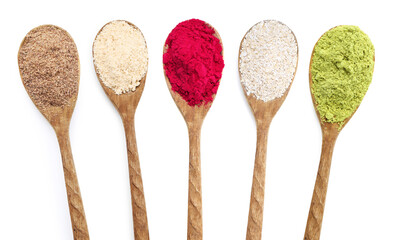 Different superfood powders in wooden spoons on white background, collage. Top view