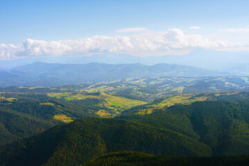 Naklejka premium Cloudy horizon over layers of Carpathian mountain ridges in summer light. Aerial view landscape