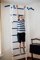 blond boy in striped t-shirt in beautiful house, minding his own business
