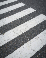 Fototapeta premium Cracked White Crosswalk Lines on Dark Asphalt Road Texture