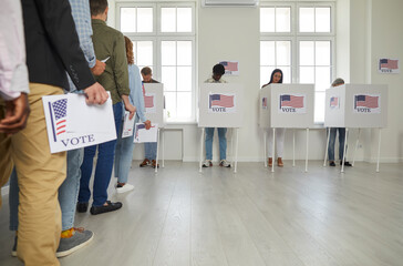Group of diverse american citizens people registering at polling station on election day and...