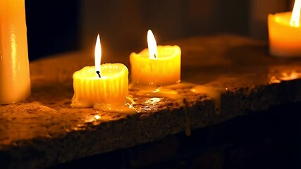 Two lit candles with melted wax on a stone surface. - Powered by Adobe