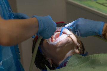 Dentist performs procedure on patient in dental clinic