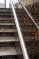 Round metal handrails at an underground passage exit glistening with raindrops after a fresh rainfall