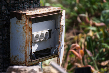 Open vintage metal cabinet providing access to electrical outlets in a park for maintenance workers