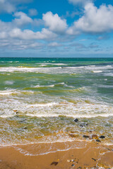 Cover page with a view of beach with clouds, blue sky and sea waves at summer sunny day