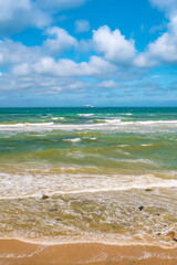 Cover page with a view of beach with clouds, blue sky and sea waves at summer sunny day