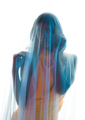 Silhouetted backlit portraits of female model draped in a sheer shroud veil, glowing with soft rim...