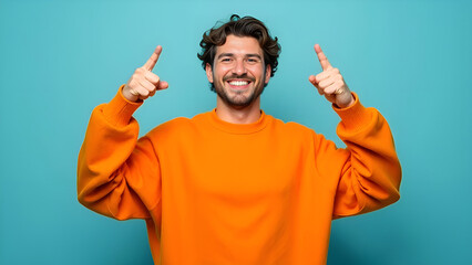 Fototapeta premium A man is joyfully pointing upwards with his fingers while wearing a big smile on his face, radiating happiness and positivity