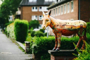 Selbstklebende Fototapeten Esel Wesel, Germany – May 31, 2025: Painted donkey statue with city landmarks on its body, part of public street art in Wesel, symbolizing local culture and history.  © Samir