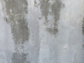 Grungy Stained Concrete Wall. A close-up of a grey concrete wall with dark, abstract stains and subtle cracks, showing signs of age