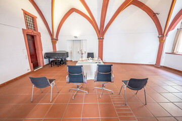 Luxurious wedding setup with round tables, stylish chairs, and beautiful floral decorations creating romantic atmosphere