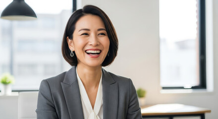 Successful confident Asian businesswoman laughing in office. Happy mature Japanese Chinese Korean female professional manager leader satisfied with corporate success. Headshot portrait.