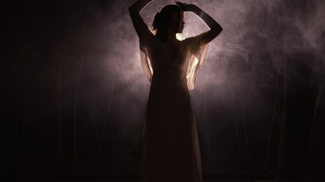 Young dancer waltzing alone in moonlit forest