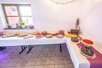 Candy bar pink wedding decorated standing of festive table with deserts, strawberry tartlet and cupcakes