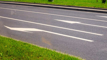 A road with two distinct white arrows clearly painted on its surface