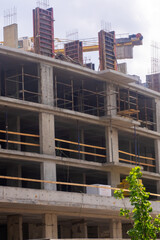 A large building being constructed with a crane in the background