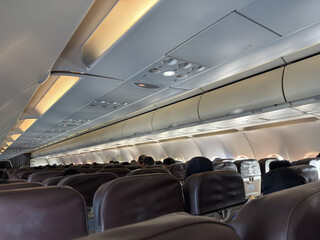 Background of airplane seats, view of passenger on plane from the back