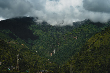 Green lush mountains and cloudy sky with a view of fountain