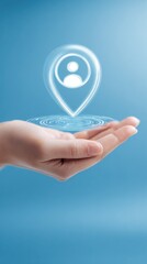 A female hand gently holds a glowing digital location pin icon with a person symbol inside a blue background