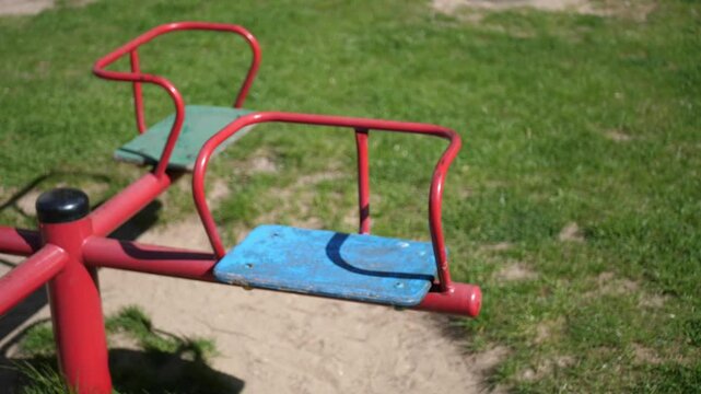 Close-up of an old colorful children&rsquo;s carousel spinning slowly on an empty playground. Vintage playground equipment in motion, nostalgic and peaceful atmosphere.