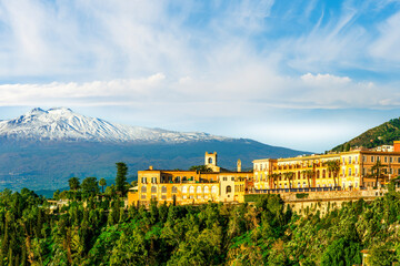 Fototapeta premium beautiful landscape of Taormina town, Italy, Sicily with scenic view at San Domenico hotel near nice buildings and panoramic view of Etna mountain on background