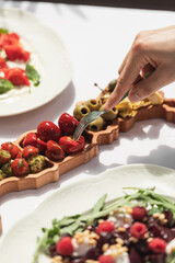 Eating marinated cherry peppers delicacy with a fork from platter