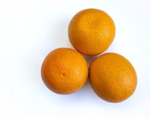 Three oranges on a white background, top view