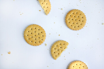 Cookies with crumbs scattered on a light background, top view