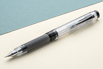 Fototapeta premium Stylish Clear Pen with Grey Grip on Neutral Background