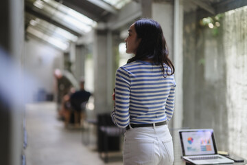 Businesswoman walking in modern office corridor looking over shoulder