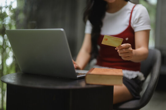 Student paying online with credit card while studying at home