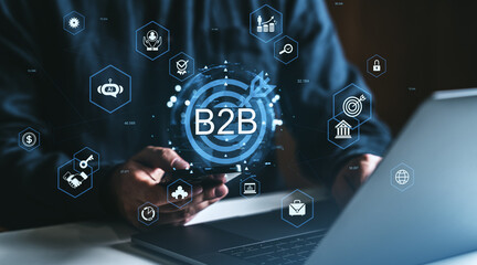 B2B technology and digital partnership concept with businessperson using smartphone and laptop surrounded by business icons on dark background.