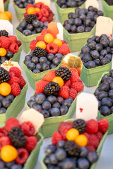Delicioso surtido de frutos rojos en mercado callejero: fresas, arándanos, moras y otras frutas deliciosas