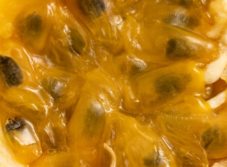 A close up of a yellow fruit with black seeds