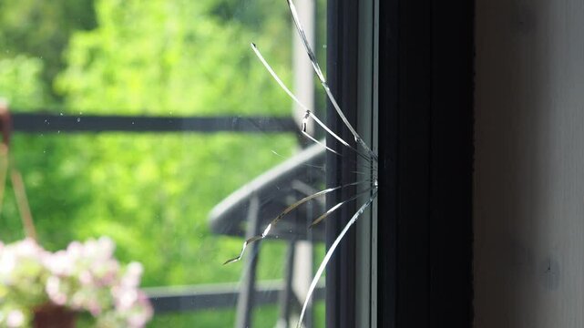 Cracked glass in the window frame. The panoramic window in the country house cracked after the shrinkage of the house. Window replacement. Glazier. Construction. vandalism or natural disaster