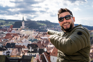 Hombre turista señalando las hermosas vistas de český krumlov, desde un mirador en altura