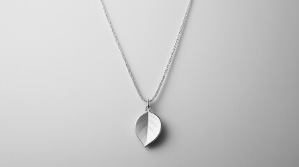 Silver necklace with leaf charm arranged vertically on clean white background