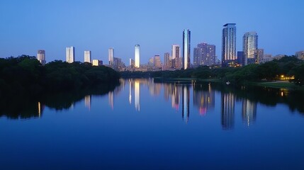 Naklejka premium Serene twilight cityscape reflected in calm waters; skyscrapers illuminate the still lake