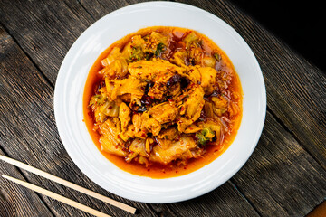 Sichuan fried chicken with vegetables on a dark background. Chinese cuisine. Food concept