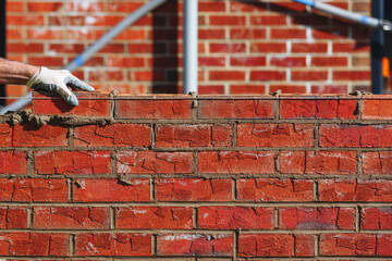 Bricklayer laying bricks on building site