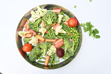 Vibrant medley of fresh vegetables. Features broccoli, cauliflower, tomatoes, Carrot, green beans, and peas. colourful vegetables of spring time, Its good for health. colorful display.