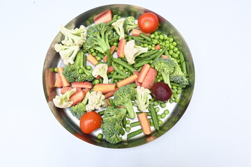 Vibrant medley of fresh vegetables. Features broccoli, cauliflower, tomatoes, Carrot, green beans, and peas. colourful vegetables of spring time, Its good for health. colorful display.